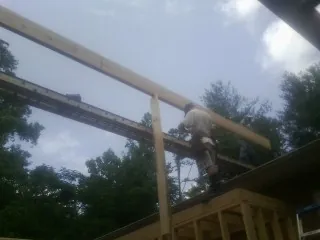Carpenter setting a ridge beam over a new addition frame — Ice Dam Removal by Roofing Brothers in Oak Lawn