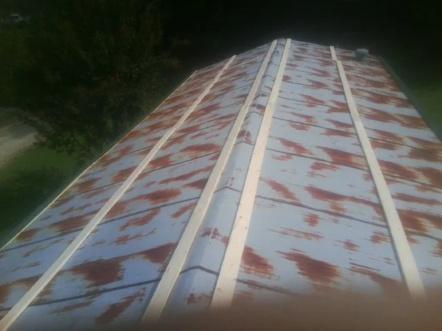 Rusted metal roof panels with new wood purlins before replacement — Storm Damage Roof Repair in Oak Lawn by Roofing Brothers