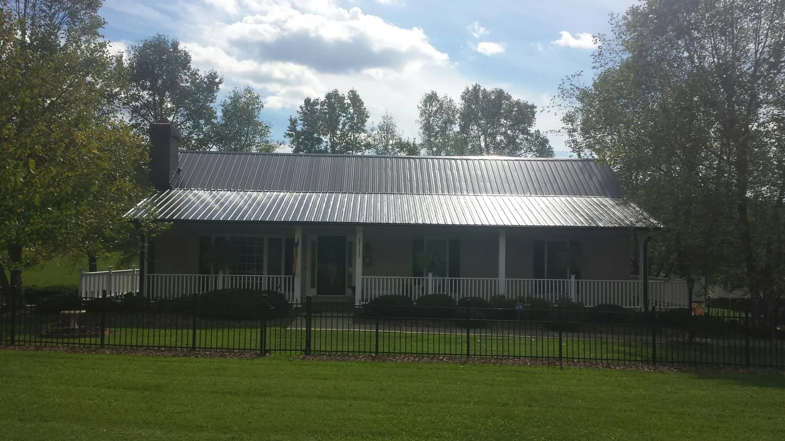 Gray metal roof on a brick ranch with a full width front porch — Gutter Guard Installation work by our crew in Oak Lawn