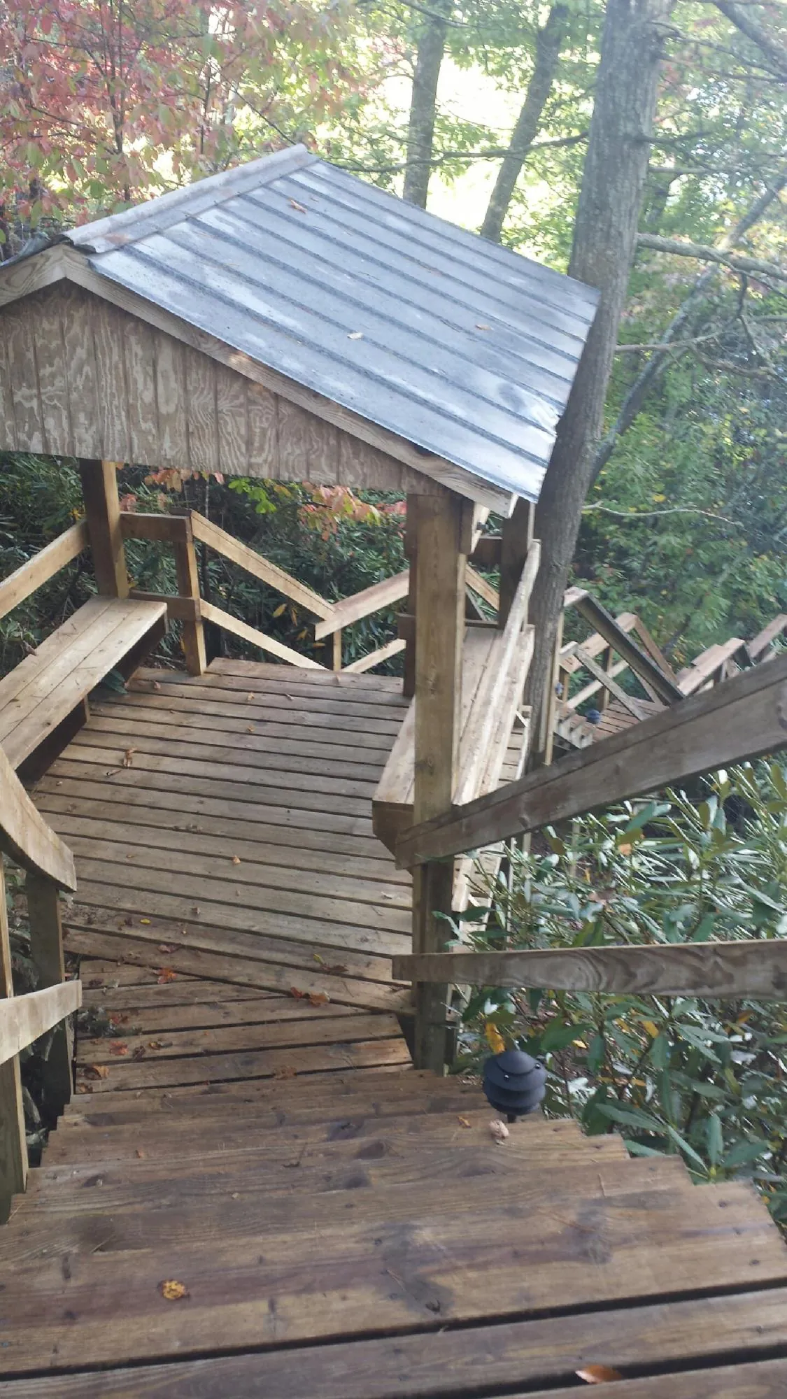 Metal roofed shelter over wooden steps on a wooded walkway — Skylight Repair & Installation work by our crew in Oak Lawn